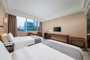 A hotel room with two beds, a desk, a chair, a TV, and a window with a view of buildings. - Zhongyi Hotel (Guangzhou Wanda Plaza Lejia Road Metro Station Branch) (Guangzhou)