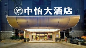 L’entrée d’un hôtel au design moderne, avec une enseigne bien visible affichant des caractères chinois et un logo.