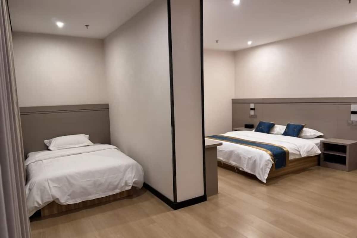 Una habitación de hotel con dos camas, piso de madera y diseño moderno.