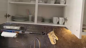 A kitchen with white cabinets, a marble countertop, and various kitchen utensils and appliances. - Vacation apartment no. 1, town center, Randersacker (Randersacker)