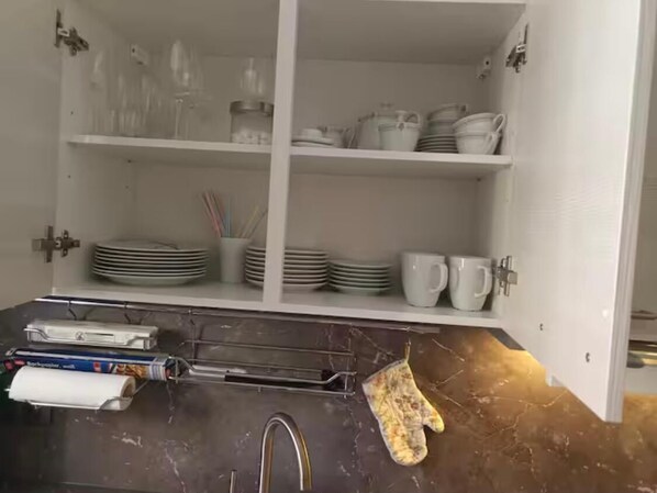 A kitchen with white cabinets, a marble countertop, and various kitchen utensils and appliances. - Vacation Apartment No. 1, Downtown, Randersacker (Randersacker)