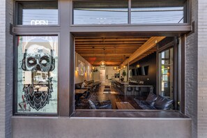 Een modern café met houten plafond, lederen zitplaatsen en een groot raam met grafisch ontwerp.