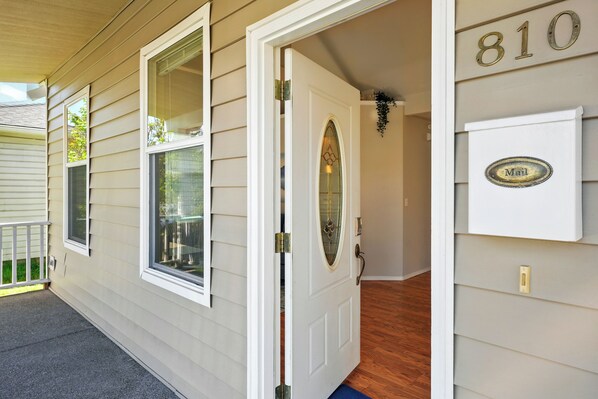 A house entrance with a door, windows, and a mailbox.