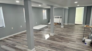 A spacious room with grey walls, wooden flooring, and white columns. - Beach Block Cozy studio with WiFi and FREE PARKING!! (Atlantic City)