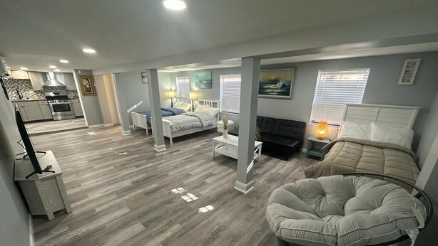 A spacious living area with a large bed, a round seating area, and a kitchen in the background. - Beach Block Cozy studio with WiFi and FREE PARKING!! (Atlantic City)