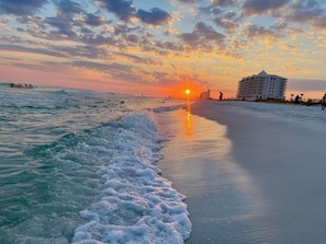 Sunset photo taken down the beach from condo building on the right