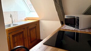 A kitchen with a wooden countertop, a sink, and a microwave. - Duplex apartment with Alsatian decor (Beblenheim)