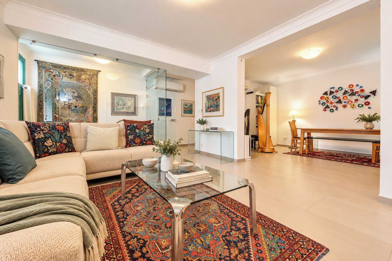 A modern living room with a sofa, coffee table, and a patterned rug.