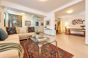 Una sala de estar moderna con sofá, mesa de centro y alfombra estampada.