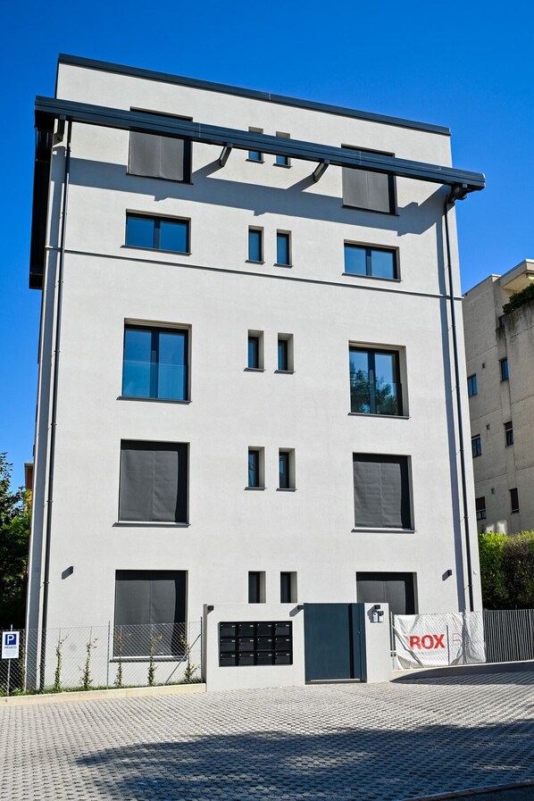 A modern multi-story building with a flat facade, large windows, and a gated entrance. - Modern Concept Suite Crocetta 7 in Lugano (Lugano)