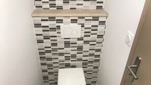 A small, modern bathroom with a tiled backsplash and a white toilet. - ARCACHON Eyrac Front de mer Apartment 68M2 with large balcony (Arcachon)