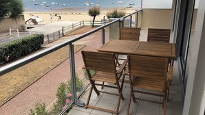 A balcony with a table and chairs overlooking a beach with boats. - ARCACHON Eyrac Front de mer Apartment 68M2 with large balcony (Arcachon)