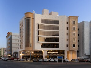 A modern hotel with a prominent entrance, multiple floors, and a parking area in front. - Amriya Hotel (Madinah)