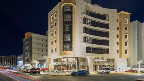 A modern hotel with multiple floors, large windows, and a prominent entrance. - Amriya Hotel (Madinah)