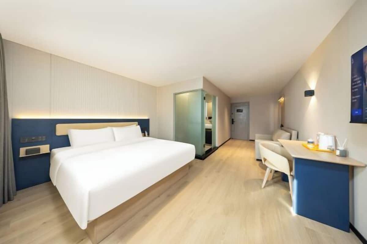 Ein Hotelzimmer mit Bett, Schreibtisch und Stuhl.