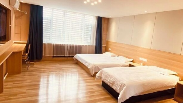 A hotel room with two beds, a desk, and a large window with blinds. - Fangxing Express Hotel (Shijiazhuang Luquan Zoo) (Shijiazhuang)