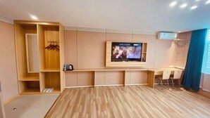 A modern room with a TV mounted on the wall, a wooden desk, and a seating area. - Fangxing Express Hotel (Shijiazhuang Luquan Zoo) (Shijiazhuang)