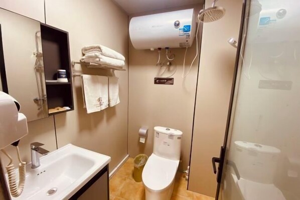 Un baño con lavamanos, inodoro, ducha y perchero para toallas.