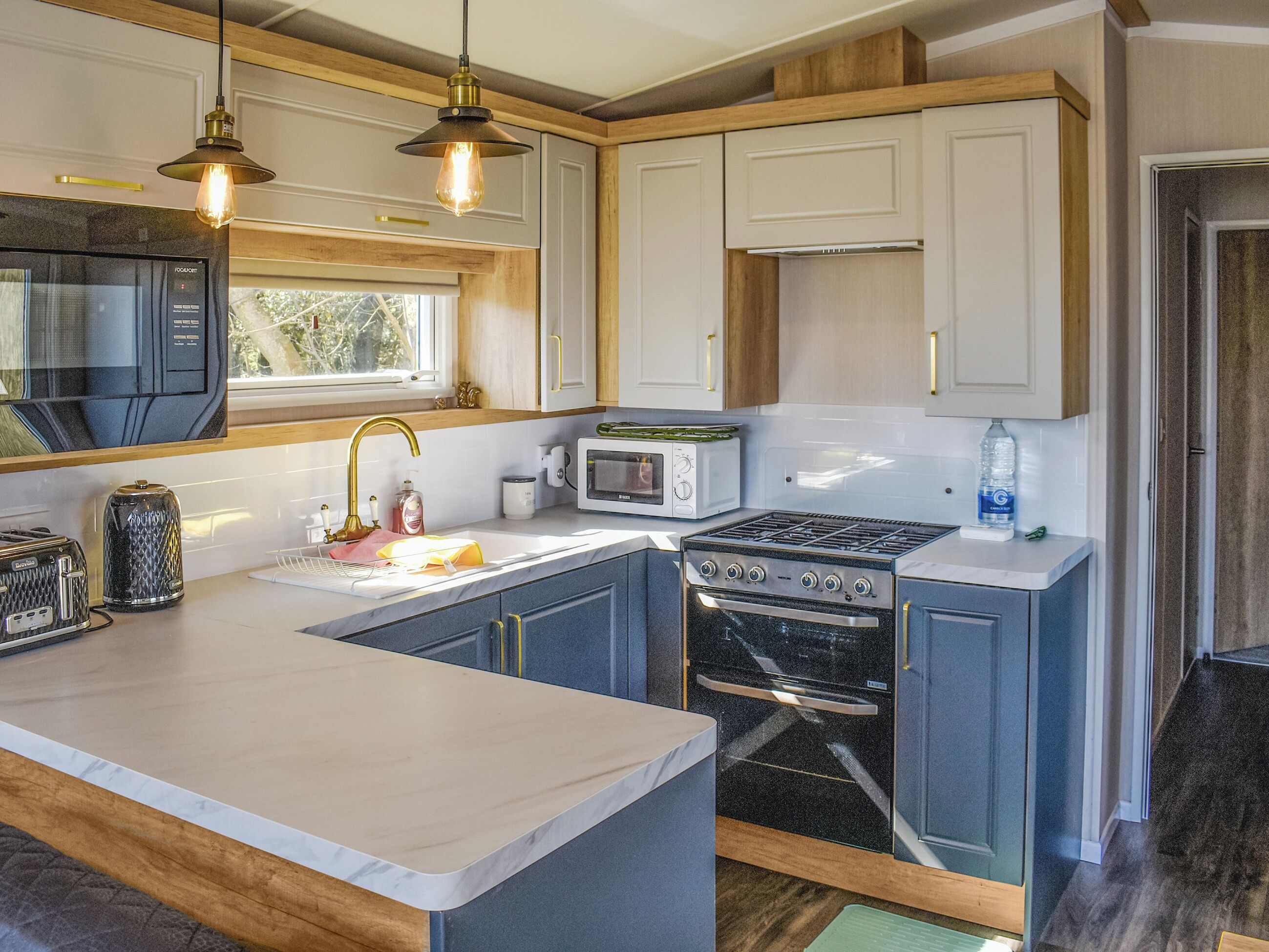 A modern kitchen with a central island, stainless steel appliances, and wooden cabinetry.