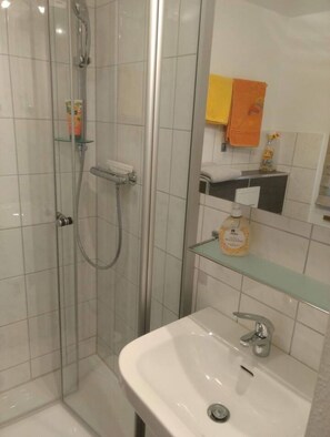 Een douche, handdoeken, zeep, toiletpapier