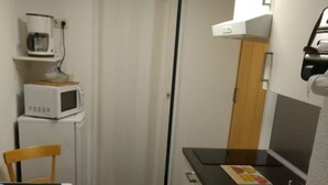 A compact kitchen with a microwave, a sink, and a small dining area. - Vacation apartment no. 2, town center, Randersacker (Randersacker)