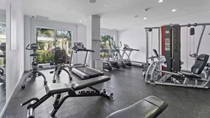 A modern gym with treadmills, elliptical machines, and weightlifting equipment. - Eagle Beach - Luxury Townhome with Private Pool - TH 11 (Noord)