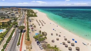 A coastal road with a beach and ocean on the right. - Eagle Beach - Luxury Townhome with Private Pool - TH 11 (Noord)