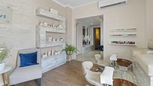 A modern salon with a marble reception desk, a blue cushioned chair, and a plant in the center. - Eagle Beach - Luxury Townhome with Private Pool - TH 11 (Noord)