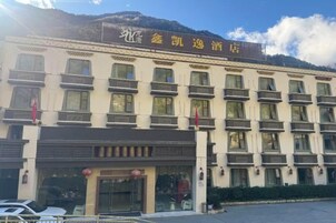 Un hotel con varios balcones, un letrero y una zona de estacionamiento.