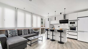 Une cuisine moderne avec des armoires blanches, un comptoir noir et un four encastré.