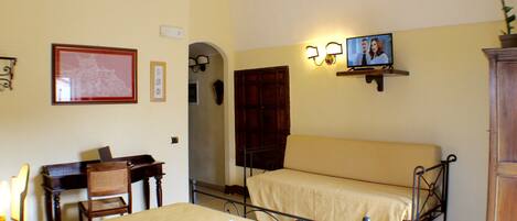 Une chambre d’hôtel comprenant un lit, un bureau avec une chaise, une table où le petit-déjeuner est servi, et un téléviseur.