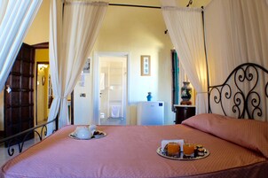 Habitación de hotel con una cama, un tray con alimentos para el desayuno y vista al pasillo.