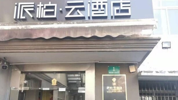A hotel entrance with a sign above the door.