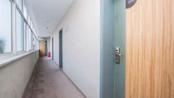 A hallway with a door labeled '306' and a fire extinguisher on the wall.