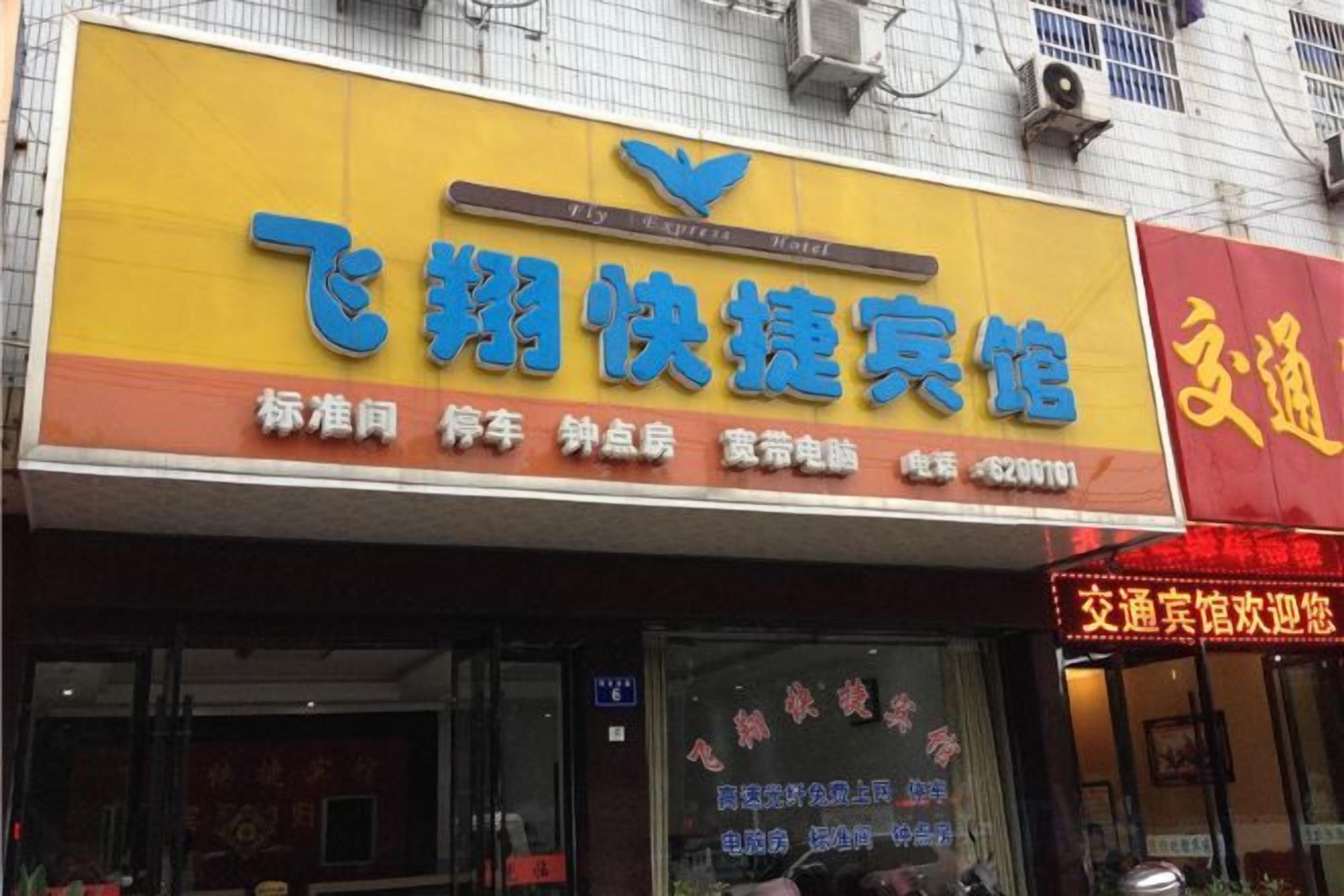 A storefront with a yellow signboard and a red signboard.