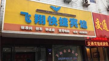 A storefront with a yellow signboard and a red signboard.