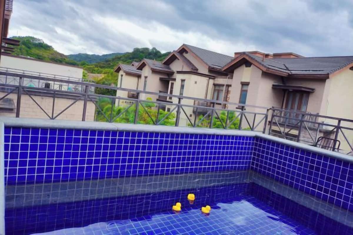 Una piscina amb rajoles blaves i una barana metàl·lica.