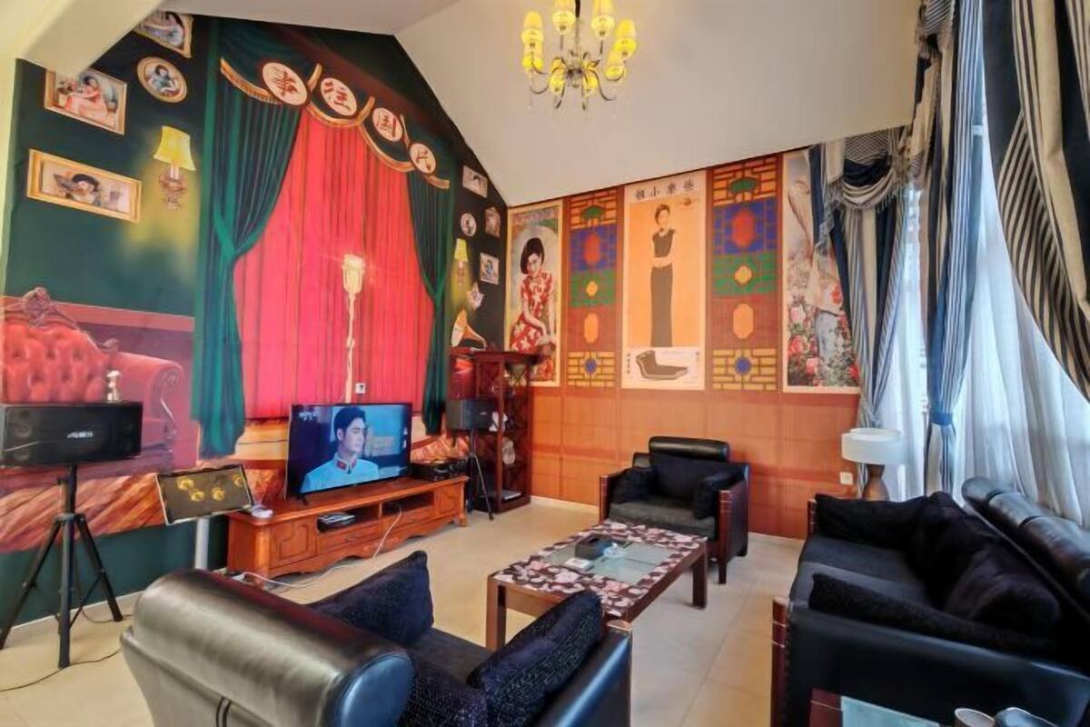 Un saló amb televisió, sofàs, una taula de centre i una paret amb diverses fotografies emmarcades.