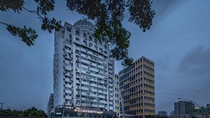 Un hotel de varios pisos con fachada curva, ventanas amplias y una entrada destacada.