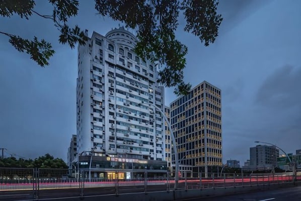 Un hotel de varios pisos con fachada curva, ventanas amplias y una entrada destacada.