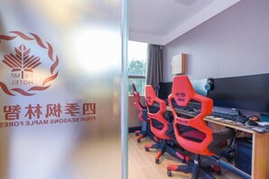 A room with gaming chairs, a desk with a computer, and a glass wall with a logo. - Four Seasons Fenglin Smart Hotel Shanghai (Shanghai Fudan University Subway Station) (Shanghai)
