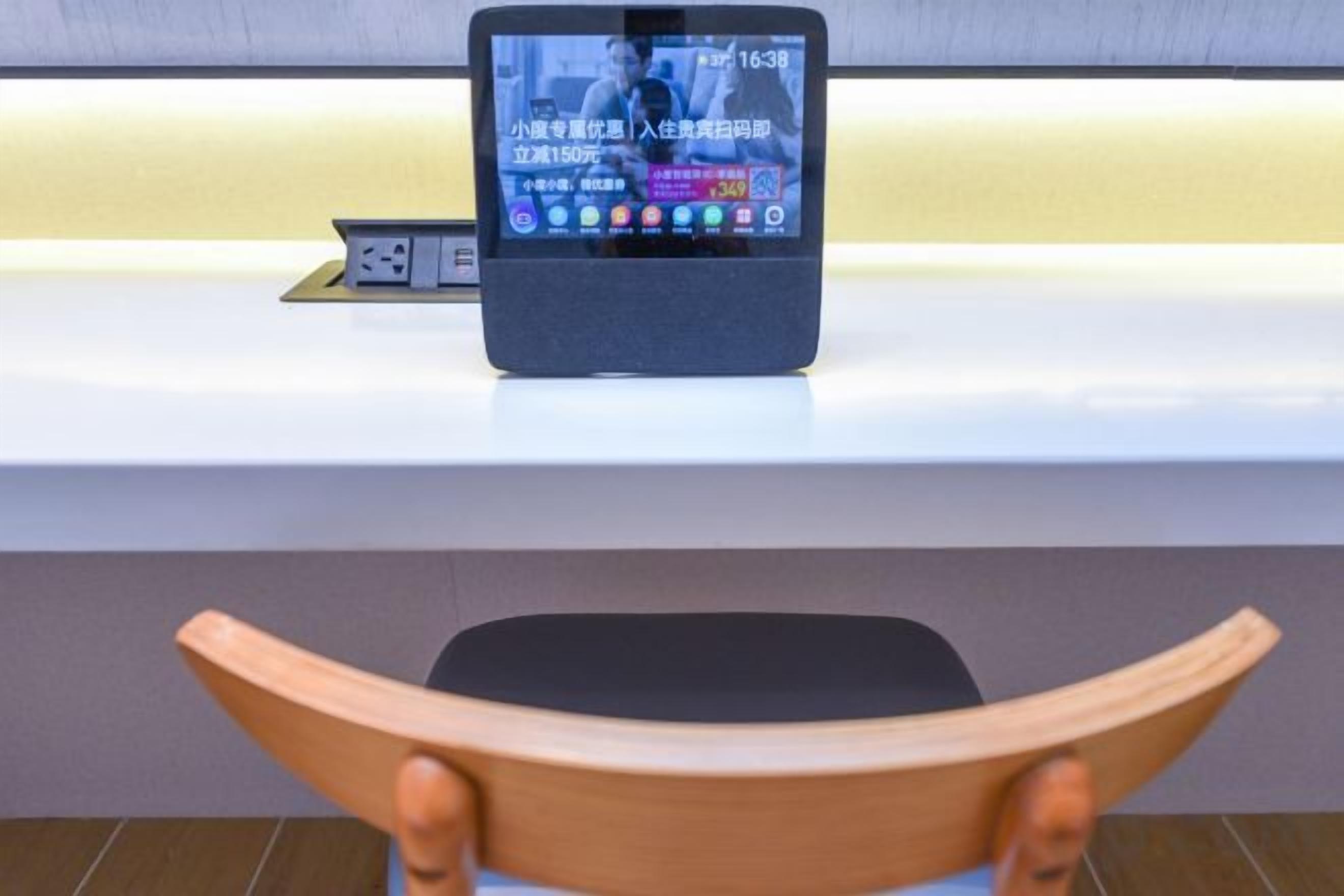 A tablet on a counter with a wooden chair in the foreground.