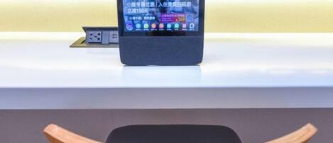 A tablet on a counter with a wooden chair in the foreground.
