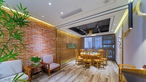 Un interior moderno con pared de ladrillo, suelo de madera, zona de comedor con mesa y sillas, y un sofá.