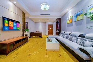Una sala de estar moderna con un sofá, una mesa de centro, un televisor y un banco de madera.