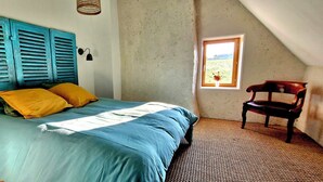 A bedroom with a bed, a window, and a chair. - Oyé's house (Oyé)