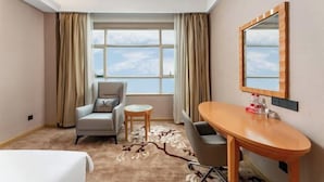 A hotel room with a bed, a desk, a chair, a round table, and a large window with curtains. - Vienna Hotel （Dongguan Changping South Station Baihua Times Square Hotel） (Dongguan)