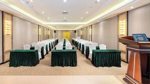 A hotel conference room with rows of tables, chairs, and a podium. - Vienna Hotel （Dongguan Changping South Station Baihua Times Square Hotel） (Dongguan)