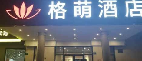 A hotel entrance with a prominent sign and a lotus symbol.