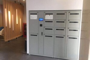 A row of grey metal lockers with a digital lock and a notice on the door. - Gemeng Hotel (Shanghai Huinan Pazhou Commercial Plaza) (Shanghai)